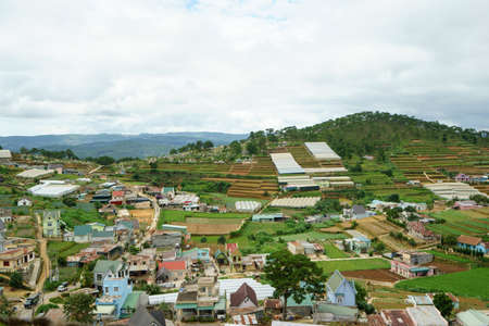 DA LAT, VIETNAM - JUNE 23, 2016: The top view on roofs and of houses and land on the city in Vietnam at cloudy day. Agricultural site, forest and mountains are on background.のeditorial素材