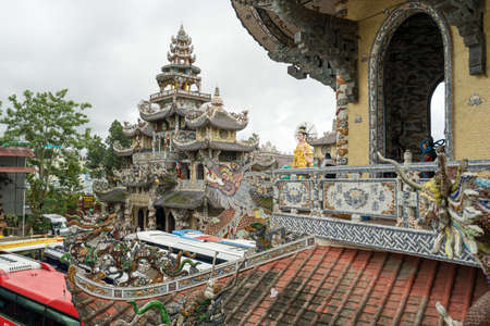 NHA TRANG, VIETNAM - JUNE 23, 2016: Big window arch on the roof. On the background there is multi-colored decorations of exterior the Buddhist temples in Vietnamのeditorial素材