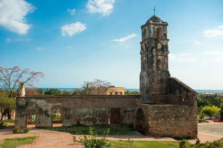 TRINIDAD, CUBA - FEBRUARY 25, 2014: Side view on ruins of old antique church in the suburb of Trinidad in hot sunny summer day. The ragged stone walls covered with a moss and a mold.のeditorial素材