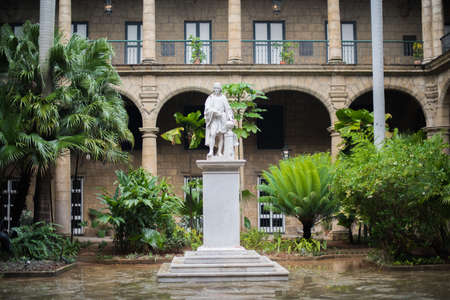 HAVANA, CUBA - OCTOBER 02, 2014: Historical monument made of a stone. A sculpture of the famous man in an internal court yard of a big ancient magnificent mansion with huge columns and arches. Plants and trees inside of house.のeditorial素材