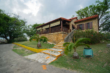 VARADERO, CUBA - APRIL 17, 2015: View of a pavement at sunset in the Cuban village. There is a small ancient wooden country house near the coastline at summer eveningのeditorial素材