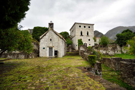 KOTOR, MONTENEGRO - NOVEMBER 13, 2014: View to chapel and fortress ruins on a stones yard with plantsのeditorial素材