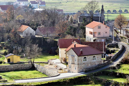 KOTOR, MONTENEGRO - NOVEMBER 15, 2014: Sunny day at Montenegro. View to the part of town in mountains. Narrow road near small houses.のeditorial素材