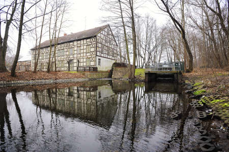 WUSTERHAUSEN, GERMANY - November 05, 2015: View to river, old water mill and houses on the shore in the middle of the forest on a cloudy day.のeditorial素材