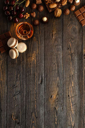 Masarons, nuts, chocolate and cherries on a wooden table. Space for textの写真素材