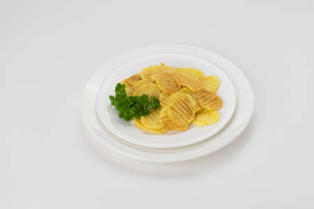 Potato chips in a plate isolated on white backgroundの写真素材