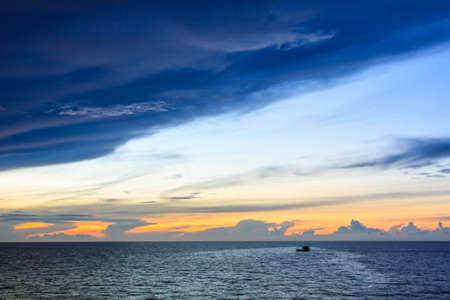Fishing boat sailing in sea with sunrise background.の写真素材