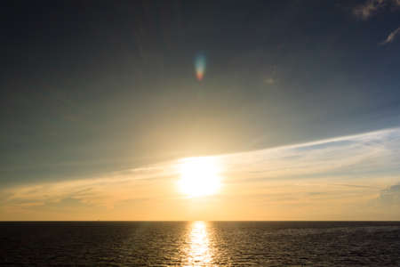 Blue sea and sky with sun red light reflexted in the middle seaの写真素材