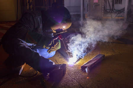 Welder perform welding to the metal plate at roof floor of manufacturing factory by using steel...