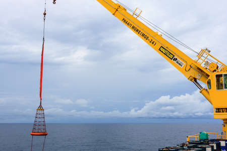 GULF OF THAILAND,SEPTEMBER 30,2017: Offshore oil and gas crane operator controling crane for lift up the personal basket to platformのeditorial素材