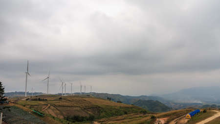 Windmills or wind turbine for generate clean electric power production on mountain with tent of...