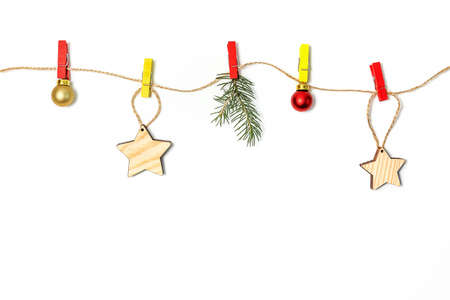 Christmas and new year holiday composition. Christmas decorations hang on colored clothespins on a rope white background. copy space.の写真素材