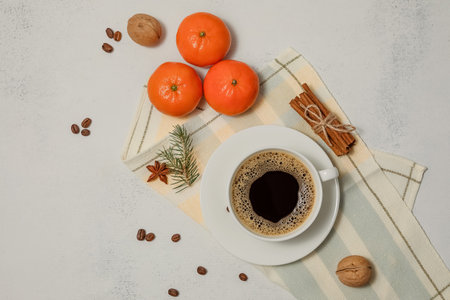 White Cup of hot coffee drink and tangerines on a light aged background. Winter composition. Holiday concept, selective focus.の写真素材
