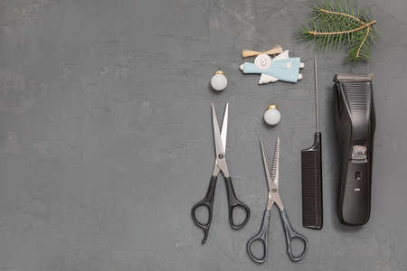 Christmas composition. Hairdressing tools on a gray background. Template for a postcard or information about a hair salon. Flat lay, copy space.の写真素材