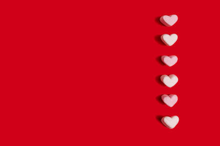 sweets-pink and white marshmallows in the shape of hearts on a red background congratulate you on...