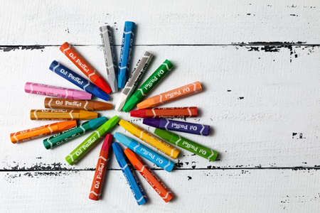 colored crayons with the inscription oil pastel for drawing on a white wooden background. a set for...
