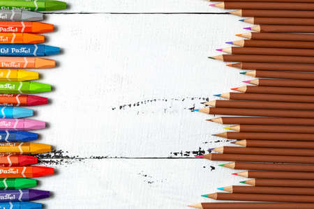 crayons with the inscription "oil pastel" and colored pencils for drawing on a white wooden background. a set for a young artist. the concept of creativity. top view.の写真素材