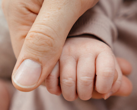 babys hand and moms palm. babys fist in momsの写真素材