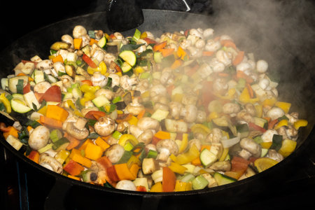 Stewing chopped vegetables over an open fireの写真素材