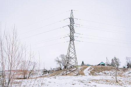 High-voltage tower in field in winter horizontalの写真素材