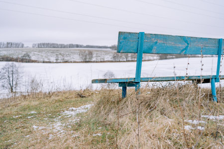 bench on a hill overlooking the lake in winterの写真素材