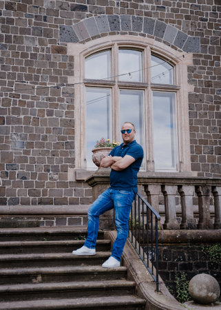 Man standing on stairs behind large stone wallの写真素材