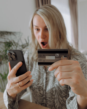 a surprised girl holding a credit card and aの写真素材
