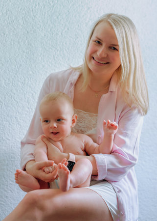 A mother of European holds a baby in a diaperの写真素材