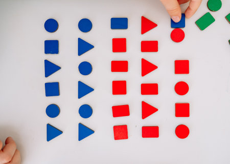 The child carefully arranges the red and blueの写真素材
