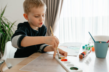 boy mixes paints in a palette