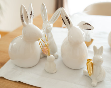 Ceramic Bunny Family with Golden Carrot on Whiteの写真素材