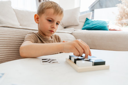 Focused Child Solving Puzzle at Homeの写真素材