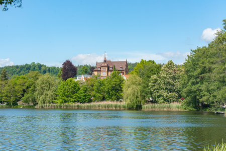 Scenic Lakeside View of Mansion and Lush Greeneryの写真素材