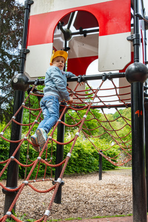 Child Climbing on Playground Rope Ladder in Parkの写真素材