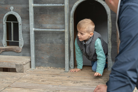 Child Crawling Out of Wooden Playhouse Door withの写真素材