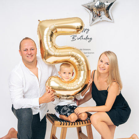 Happy family celebrating chils 5th birthday withの写真素材
