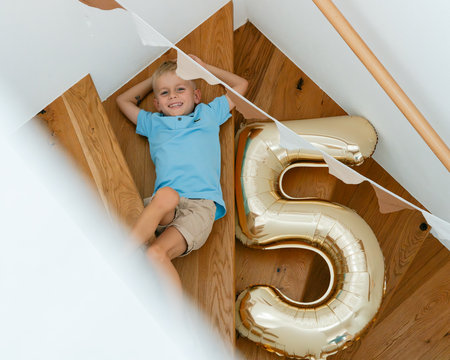 Child Celebrating Birthday with Gold Balloon on