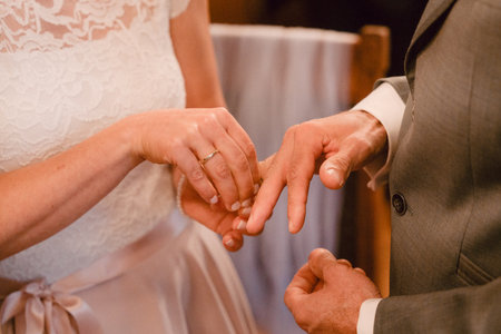 Bride Places Ring on Grooms Finger in Ceremonyの写真素材