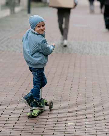 Boy in blue jacket and hat enjoying city walk on