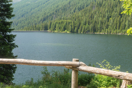 Alpine lake with wooden fence in foregroundの写真素材