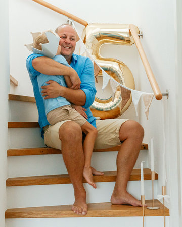 Joyful Father Hugging Son on Birthday Celebrationの写真素材