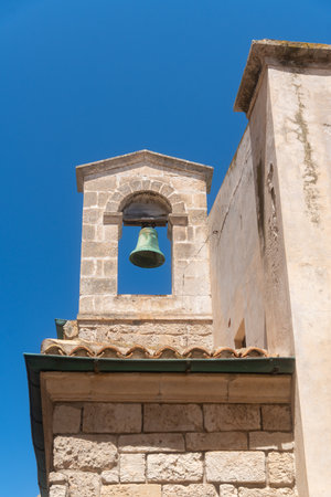 Ancient Stone Bell Tower Against Clear Blue Skyの写真素材
