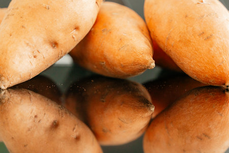 Close-up of fresh orange yams with reflectionの写真素材