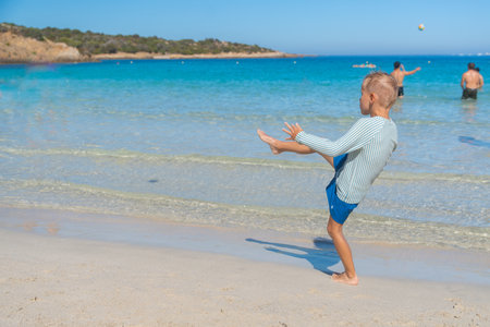 Boy Playing with Ball at Shoreの写真素材