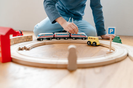 Child assembling wooden railway track and trainの写真素材