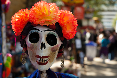 Skull painted and decorated with orange paper mache flowers and earrings/decorated skull for Dia de los Muertos, Day of the Deadの写真素材