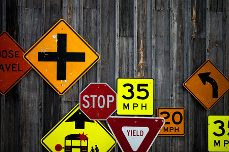 Collection of various road signs on rustic wooden wallの写真素材