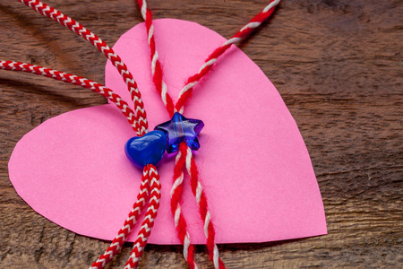 Small blue heart and star on red and white bakers twine with pink paper heartの写真素材