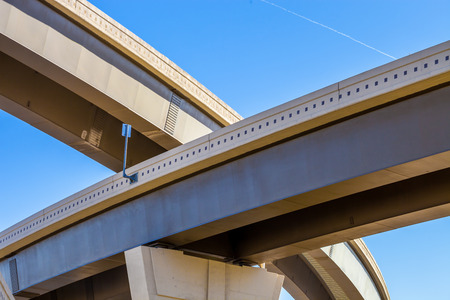 Section of elevated higway with several levels against a bright blue sky