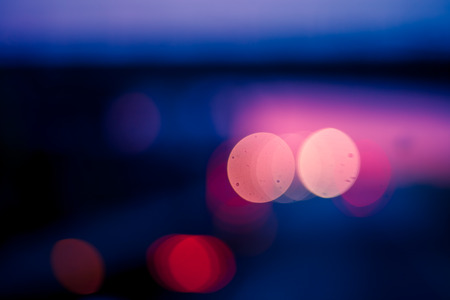 Blurred abstract background with red and pink bokeh and tones of blue and black